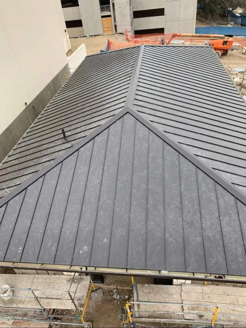 Commercial metal roof construction with crane equipment in Waterford